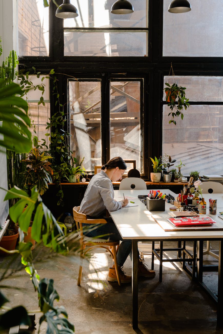 photo of woman sitting by the table